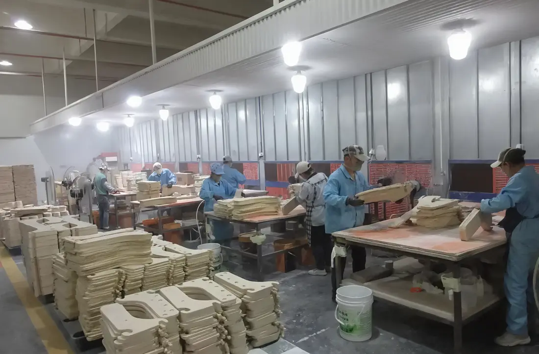 Workers sanding and checking wooden learning tower components before finishing